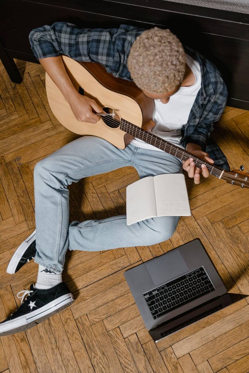 man learning to play guitar through asynchronous music lesson